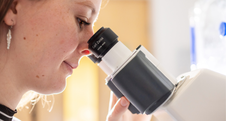 Woman looking into a microscope